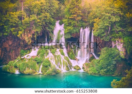 Plitvice Lakes National park, beautiful waterfall in the autumn forest, which flows into the emerald lake, popular tourist destination in Croatia. Nature background for wallpaper, cover or guide book