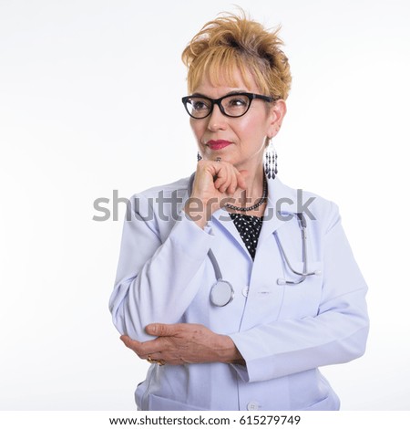 Close up of senior Asian woman doctor thinking while wearing eyeglasses against white background