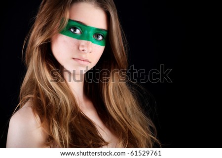 Shot of a beautiful young woman with painted eyes. Posing over black background.