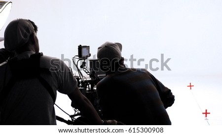 Movie director and photographer are talking or consulting to making studio set before shooting video production and silhouette background lighting.