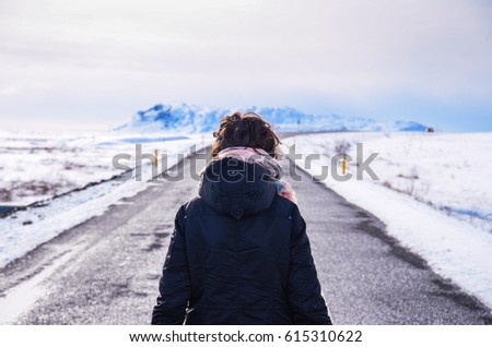 woman standing on empty iceland road - wallpaper, winter, fashion travel concept photo