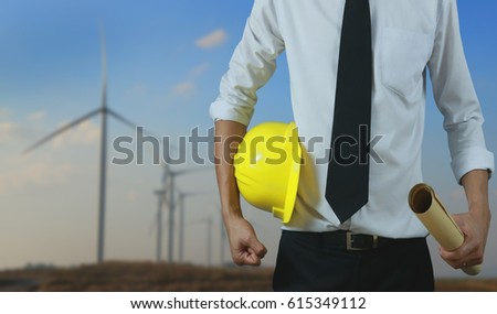 engineer yellow helmet for workers security control high voltage system on the background of Wind turbine generates high voltage.for banner website