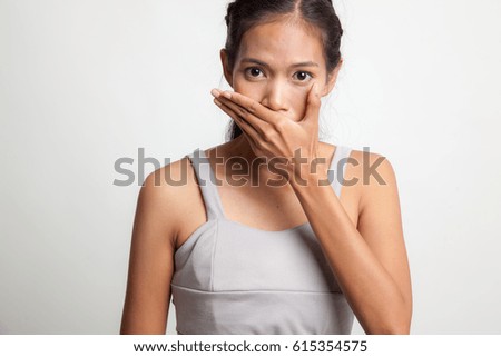Young Asian woman close her mouth with hand on white background