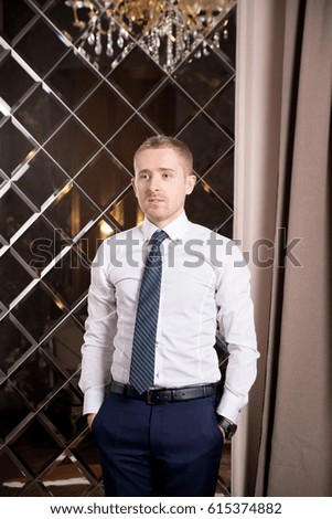 Man in white shirt and tie in luxury interior