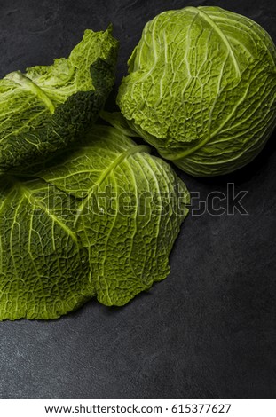 Moody low light picture of fresh cabbage at stone black table