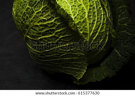 Moody low light picture of fresh cabbage at stone black table