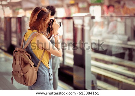Tourist woman taking travel picture with camera of skyline during autumn holidays. View from the back.
