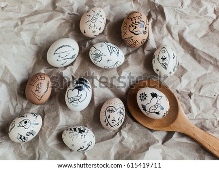 Easter eggs painted with doodles and wooden spoon on parchment