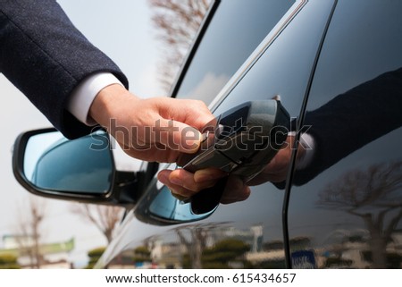 Close-up of male hand holding the car door/door for automotive/Car smart key Royalty-Free Stock Photo #615434657
