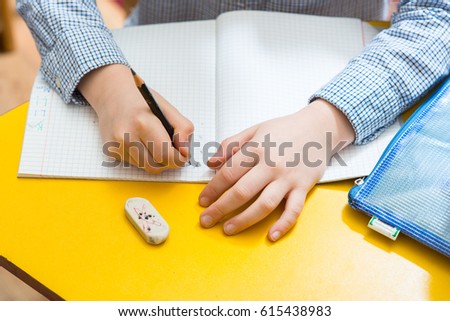 Children on the writting lesson at school with their school supplies