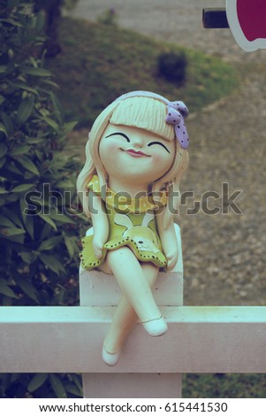 dolls decoration in the garden laughing ,happiness the doll sitting on a white fence. for decorate in the garden