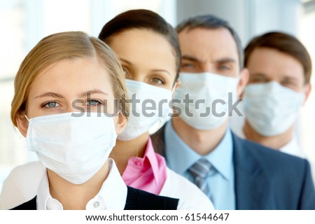 Pretty female in protective mask looking at camera with row of partners behind Royalty-Free Stock Photo #61544647