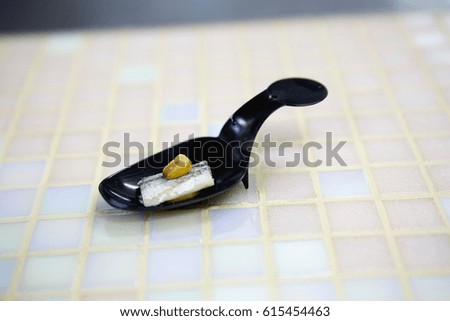 Black spoon with fish appetizer. Molecular cuisine. Horizontal format. Close up picture. 