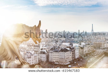 Beautiful view to the whole city of Paris from the top of Notre Dame. An iconic statue of the Cathedrale in the foreground with a ray of sunlight and a flare. The Eiffel Tower visible in the horizon.