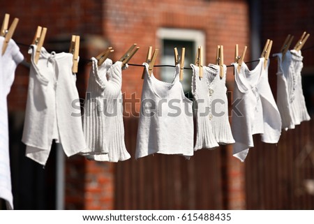 Vintage underclothing hanging to dry pinned to a line with old style clothespins in Dokkum, The Netherlands Royalty-Free Stock Photo #615488435