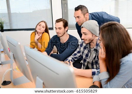 group of five young people student with teacher in computer school classroom learning programming with desktop computer in a row