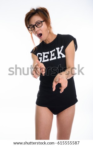 Studio shot of young Asian geek girl looking shocked while pointing at camera with no pants against white background
