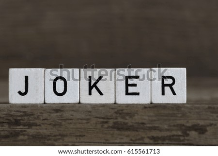 Joker, written in cubes on a wooden background