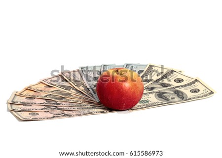 A ripe fresh red apple lies on a pile of American dollars