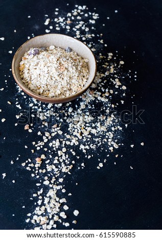 Oatmeal or oat flakes on dark wooden table