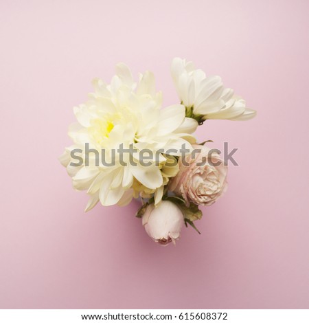 Bouquet of white chrysanthemums and cream roses on a pink background. Flat lay