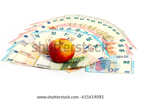 A beautiful ripe fresh apple lies on a pile of European paper currency euro