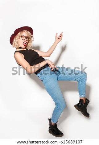 Young stylish casual dressed woman gesturing the guitar playing on the white background.