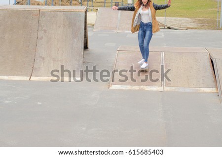Cool skater girl riding a long board at the city