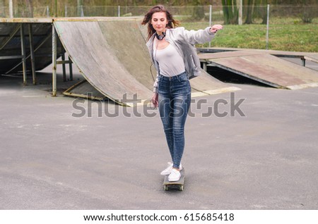 Cool skater girl riding a long board at the city