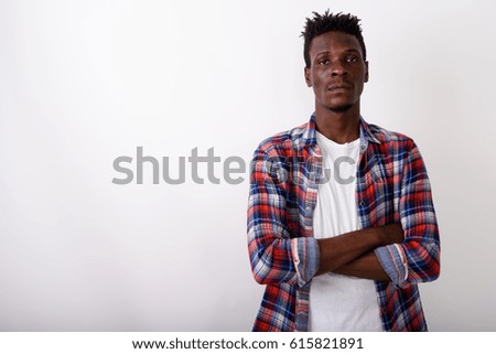 Studio shot of young black African man with arms crossed against white background