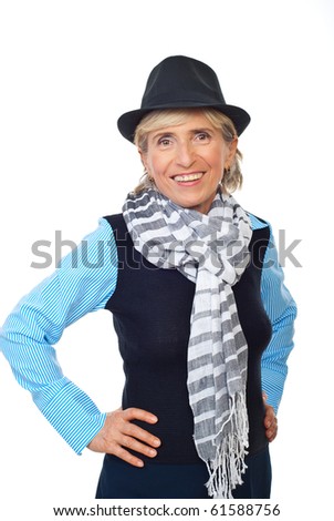 Smiling senior woman wearing hat and scarf and posing with hands on hip isolated on white background