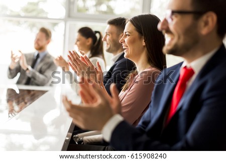 Happy group of businesspeople clapping in office Royalty-Free Stock Photo #615908240