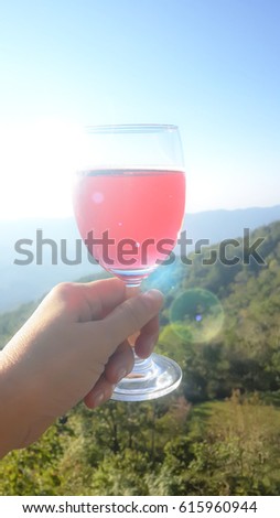 Picture of 2 hands holding  2 glass of solfdrink , moutain background blur, celebration on nature view concept.