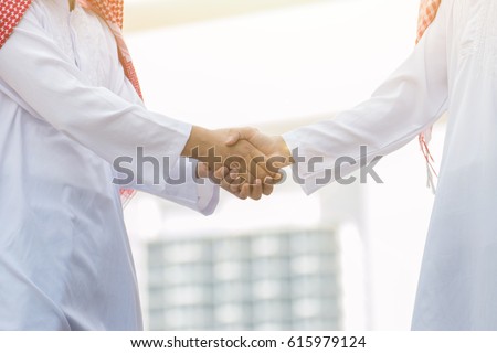 Arab Business handshake and business people on city background Royalty-Free Stock Photo #615979124