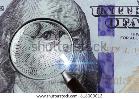 100 US Dollar under magnifying glass. close-up