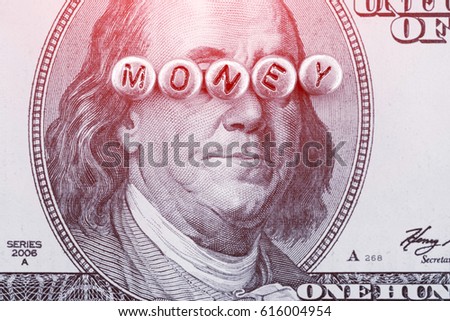 Portrait of Benjamin Franklin on the hundred dollar banknote with the inscription MONEY made of silver beads. Toned