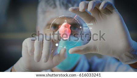A physician, surgeon, examines a technological digital holographic plate represented the patient's body, the heart lungs, muscles, bones. Concept: Futuristic medicine, world assistance, and the future Royalty-Free Stock Photo #616033241