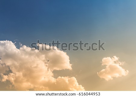 Blue and orange light in sky with bright clouds