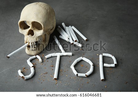 No smoking concept. Word STOP made of cigarettes and skull on grey background