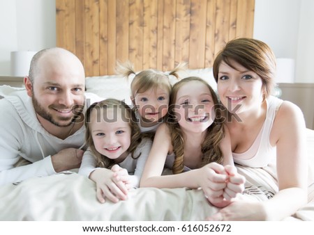 A Young happy family of five on bedroom