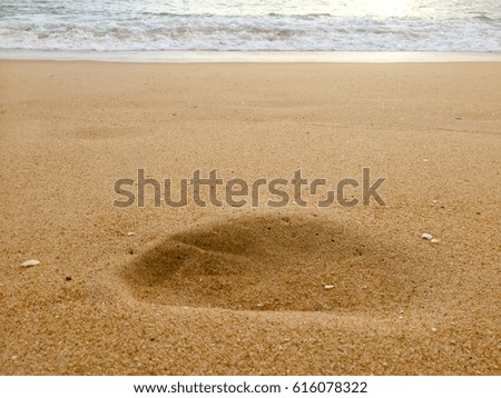 Closeup on foot print on sandy surface beach texture background. Summer travel, copy space concept