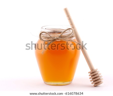 Honey in the glass jar is beside the attributes