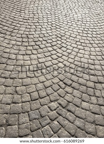 Square paving stone in round setting.