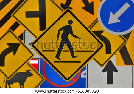 Beware crossing man symbol on traffic sign background
