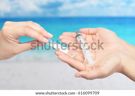 Female hands holding injection needle 