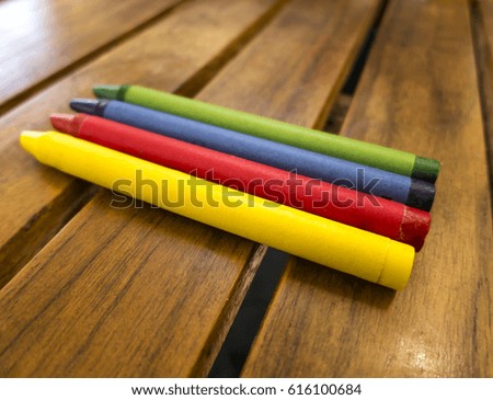 Various colored crayons on a wooden table.