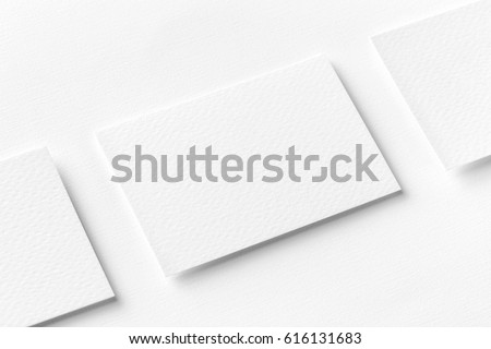 Mockup of three horizontal business cards at white textured background.