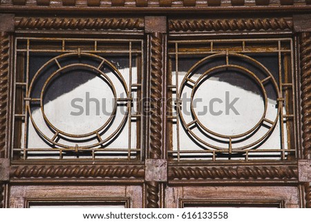 Old wooden windows with metal bars, reflection of the sky