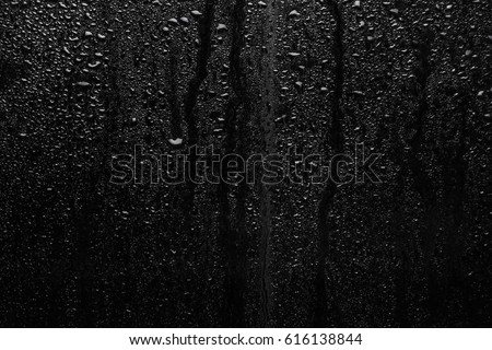 Part of series. Background photo of rain drops on dark glass, different size: small medium and large, horizontal view