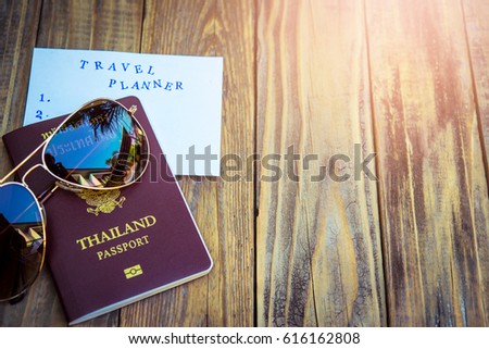 classic Glasses on passport book with travel planner note
